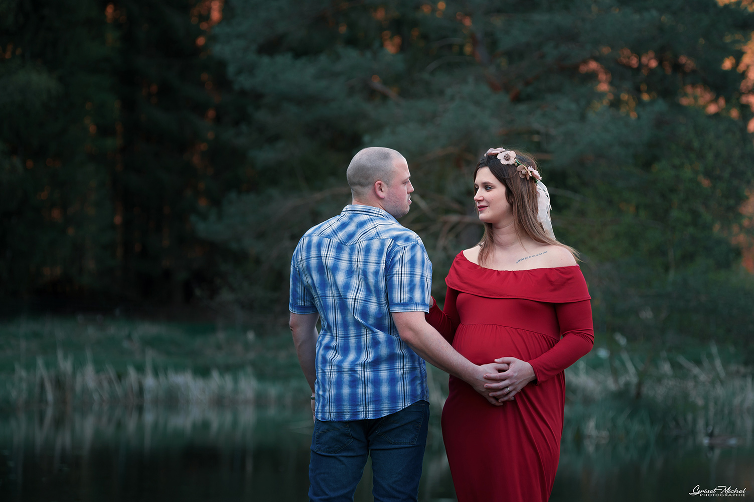 une femme enceinte regard le futur papa avec passion au bord d un etang de peche