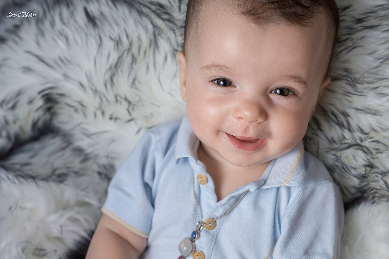 Bebe-naissance petit garcon allongée sur un tapis blanc et gris