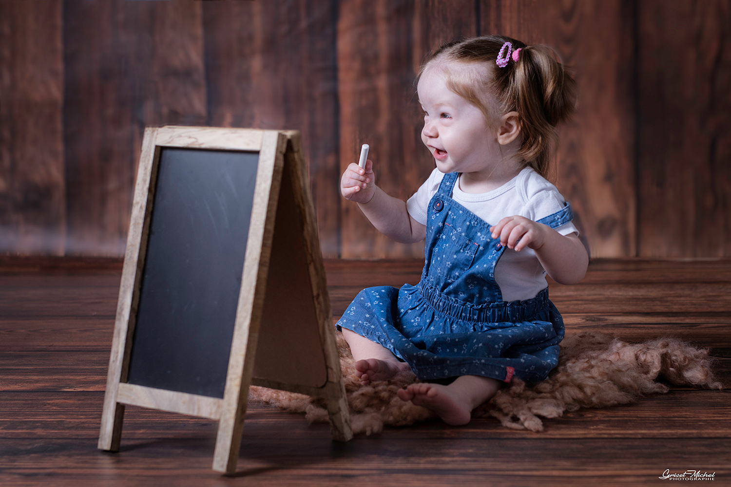 un bebe avec une craie et un tableau
