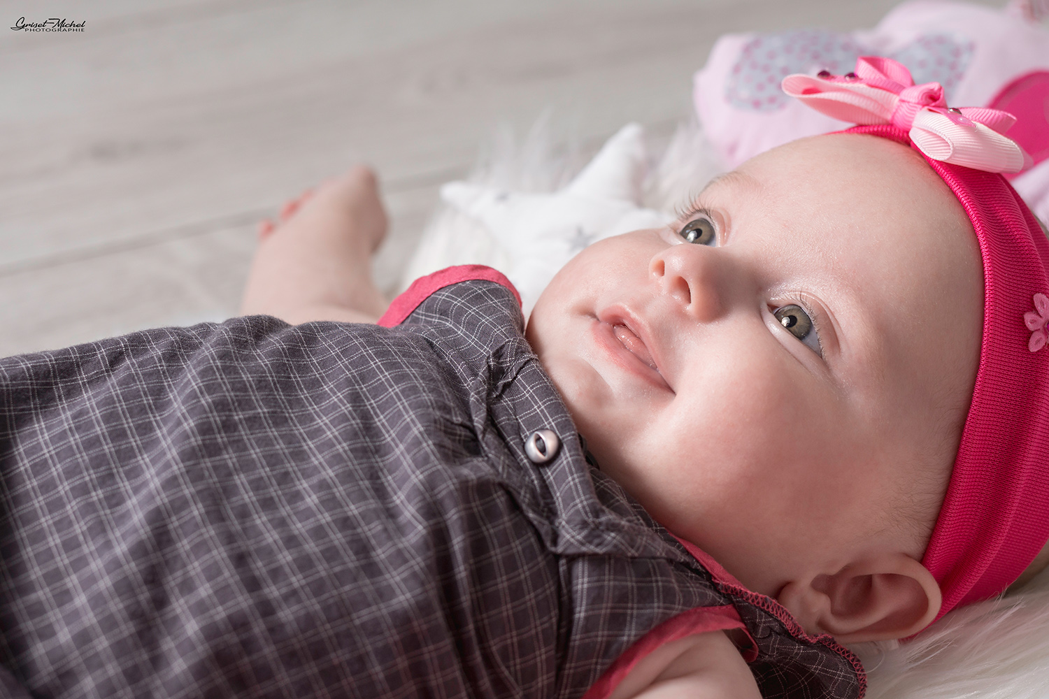photo de bebe en studio photo avec un bandeau rose