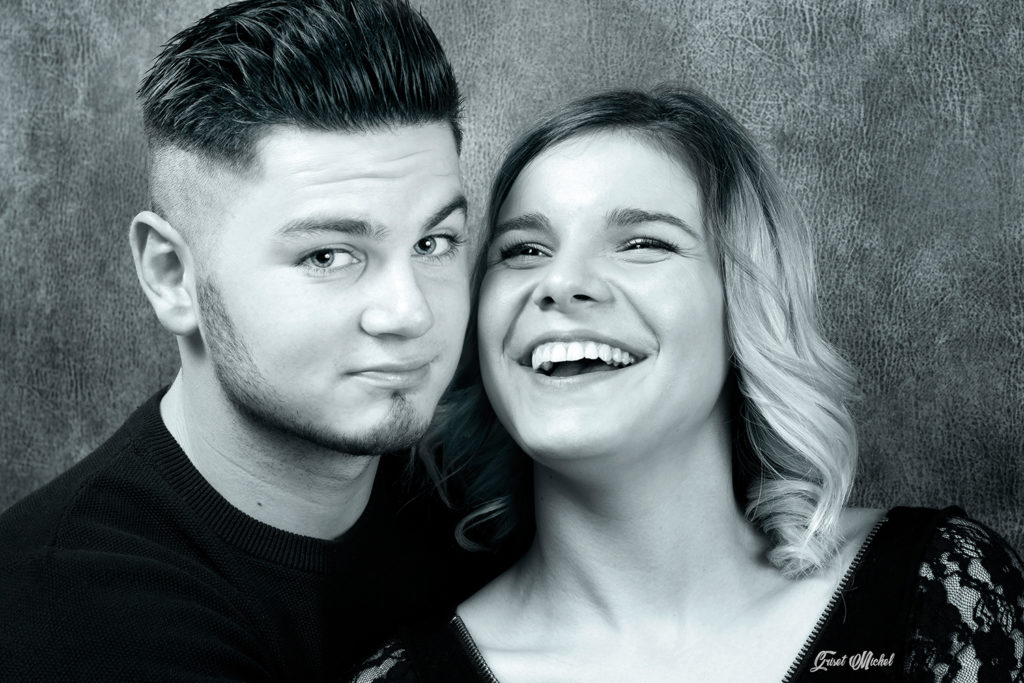 couple en studio photo un homme qui nous regard et une femme qui rigole
