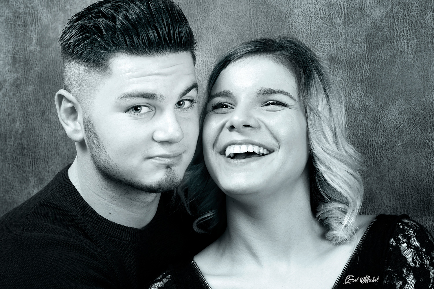 couple en studio photo un homme qui nous regard et une femme qui rigole