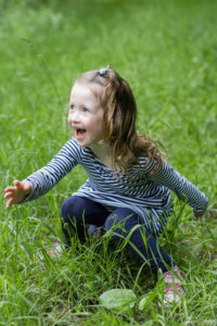 une fillette assis dans l herbe qui joue avec son pere