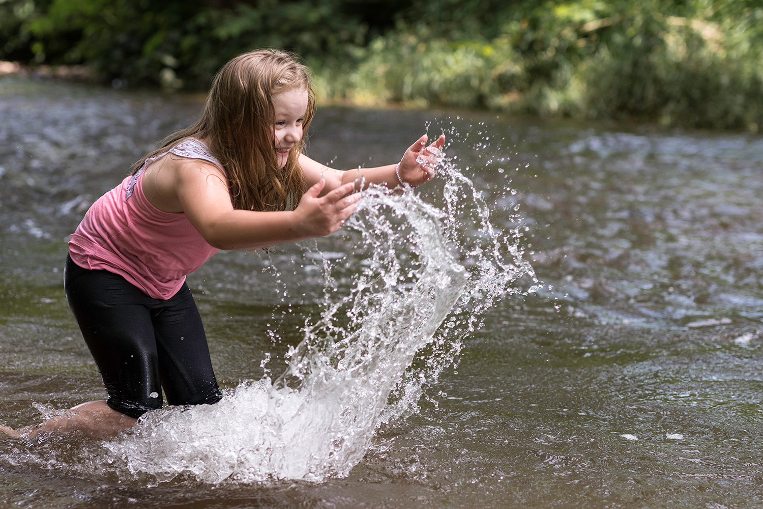 une jeune fille qui joue avec l'eau