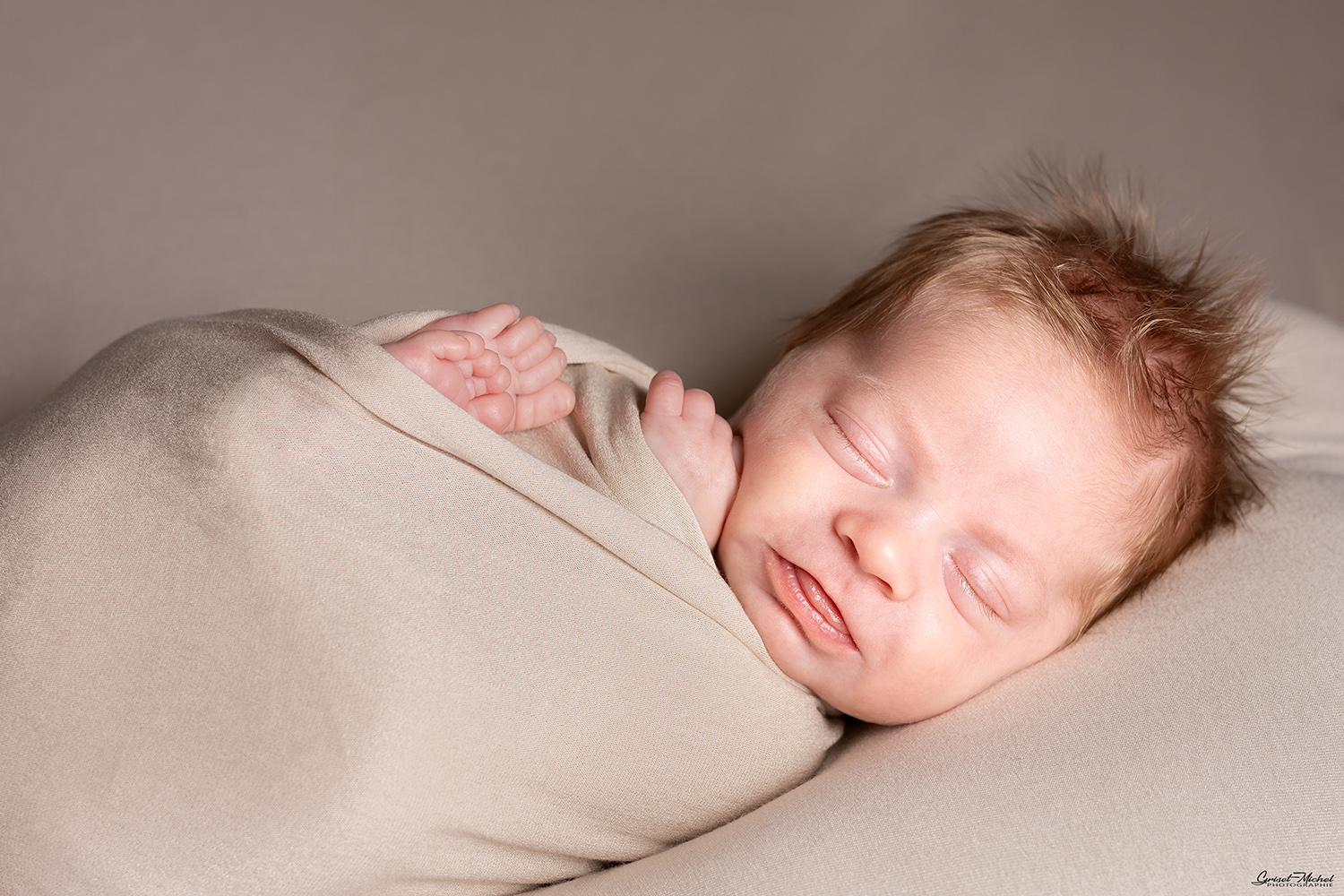un nouveau ne emmailloter avec un wrap jersay qui dort sur un coussin