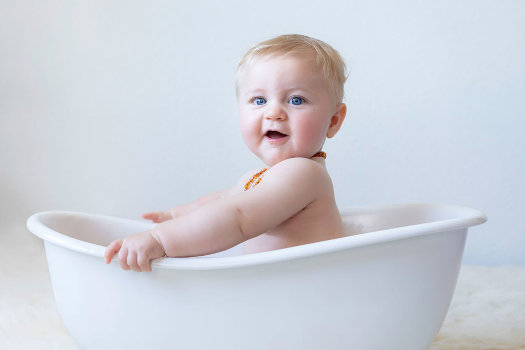 seance bebe en studio avec un petit garcon dans une baignoire qui rigole