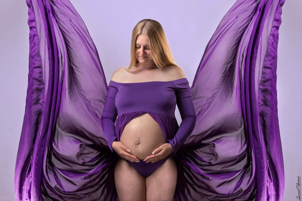 grossesse creative une femme forme un papillon avec sa robe en studio
