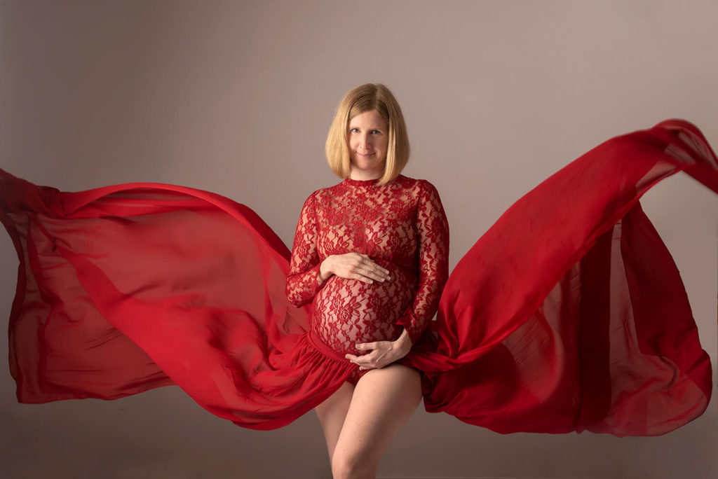 femme enceinte avec une robe rouge petante avec un voile qui vole