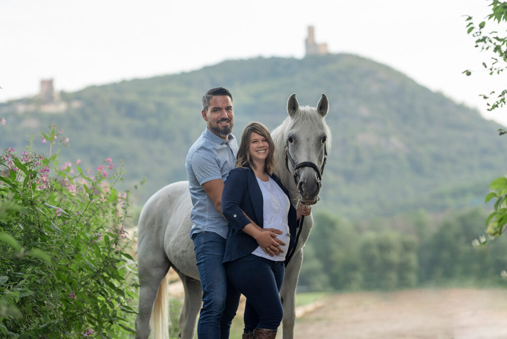 Paysage champêtre château alsacien en arrière-plan d'une séance photo de grossesse en compagnie d'un cheval à Chatenois